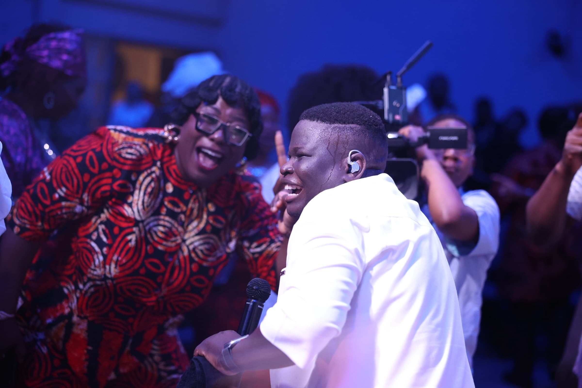 A worship leader singing with joy as the congregation celebrates